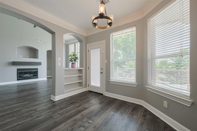 9526 Fern Wood Frst, Houston, TX 77040 - foyer with healthy amount of natural light, a chandelier, dark wood-style floors, a glass covered fireplace, and ornamental molding