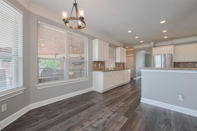 9526 Fern Wood Frst, Houston, TX 77040 - kitchen with freestanding refrigerator, a chandelier, ornamental molding, tasteful backsplash, and white cabinets