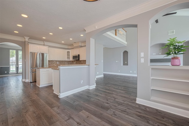 9526 Fern Wood Frst, Houston, TX 77040 - kitchen featuring appliances with stainless steel finishes, crown molding, built in shelves, glass insert cabinets, and white cabinets