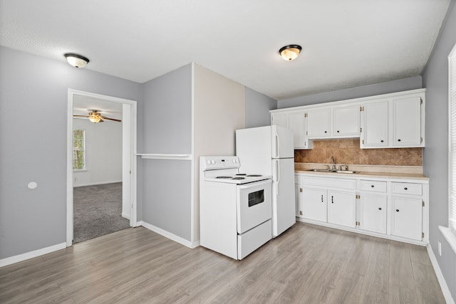740 Post St, Houston, TX 77022 - kitchen with white appliances, light wood-style floors, a ceiling fan, and white cabinets