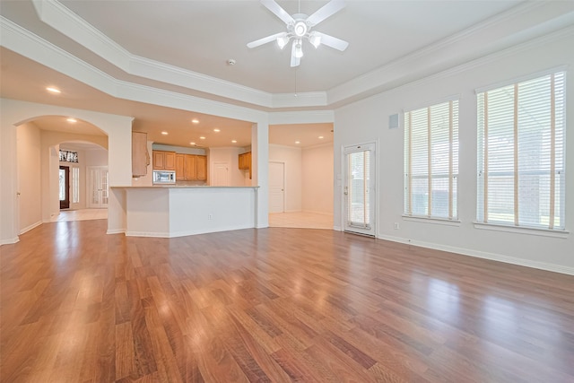 7927 Chateau Point Ln, Houston, TX 77041 - unfurnished living room with a ceiling fan, plenty of natural light, arched walkways, light wood-style floors, and ornamental molding