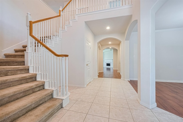 7927 Chateau Point Ln, Houston, TX 77041 - entryway featuring arched walkways, stairway, a high ceiling, light tile patterned floors, and a fireplace