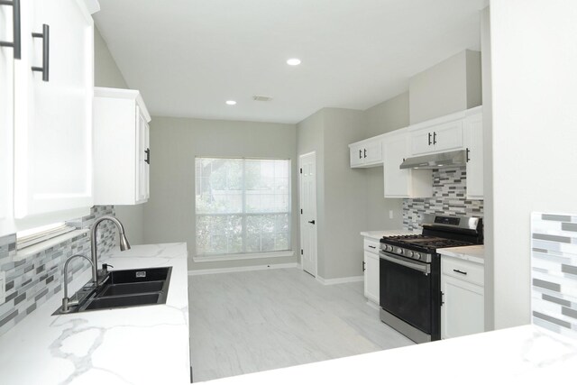 2522 Cardinal Elm St, Fresno, TX 77545 - kitchen featuring stainless steel range with gas stovetop, under cabinet range hood, light stone counters, backsplash, and recessed lighting