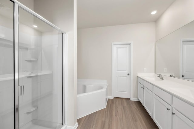 14109 Freeboard Dr, Texas City, TX 77510 - bathroom featuring a stall shower, wood finished floors, a bath, double vanity, and recessed lighting