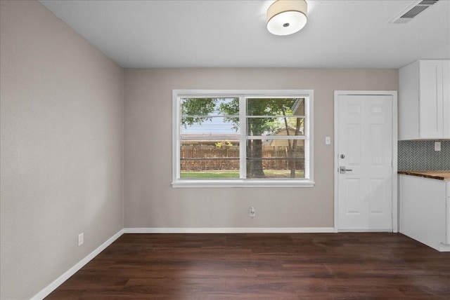 2909 15th Ave N, Texas City, TX 77590 - unfurnished dining area with dark wood-style floors and baseboards
