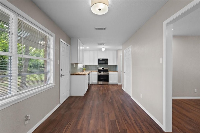 2909 15th Ave N, Texas City, TX 77590 - kitchen with stainless steel electric range oven, black microwave, dark wood-style flooring, decorative backsplash, and white cabinetry
