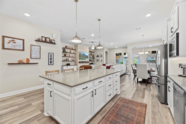 11819 Dockside Shores Dr, Cypress, TX 77433 - kitchen featuring appliances with stainless steel finishes, a chandelier, healthy amount of natural light, light wood-style floors, and recessed lighting
