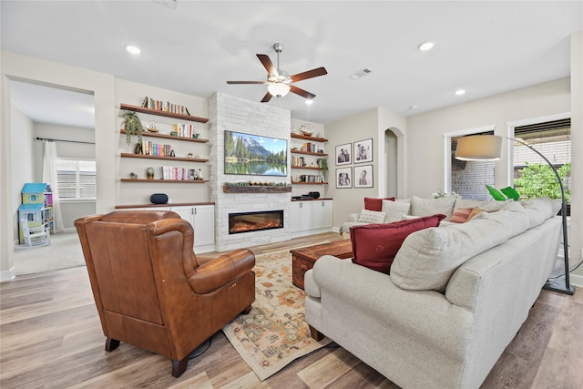 11819 Dockside Shores Dr, Cypress, TX 77433 - living area featuring a stone fireplace, light wood-style flooring, a ceiling fan, and recessed lighting