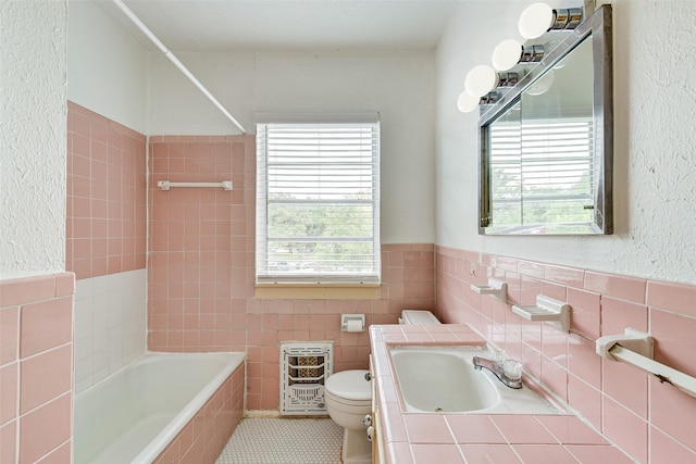 1737 Branard St, Houston, TX 77098 - full bathroom featuring tile walls, heating unit, tile patterned flooring, vanity, and tiled shower / bath