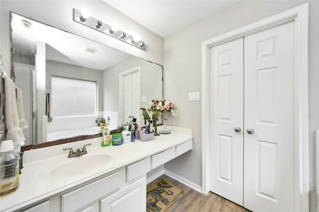 14503 Brackenhurst Ln, Houston, TX 77049 - bathroom with vanity, wood finished floors, and a garden tub