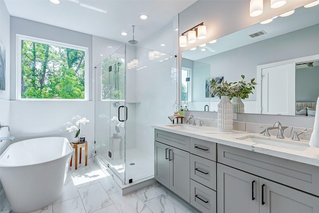 1850 W Tidwell Rd, Houston, TX 77091 - full bathroom featuring a shower stall, double vanity, a freestanding tub, marble finish floors, and recessed lighting