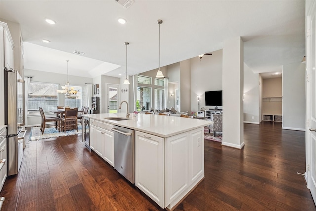 18311 Windspring Falls Ln, Cypress, TX 77433 - kitchen featuring stainless steel appliances, dark wood-style floors, light countertops, white cabinets, and hanging light fixtures