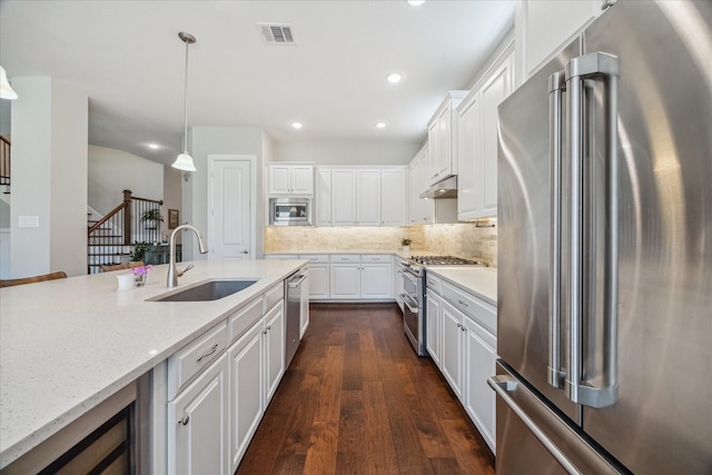 18311 Windspring Falls Ln, Cypress, TX 77433 - kitchen with high quality appliances, dark wood-style floors, white cabinets, under cabinet range hood, and wine cooler