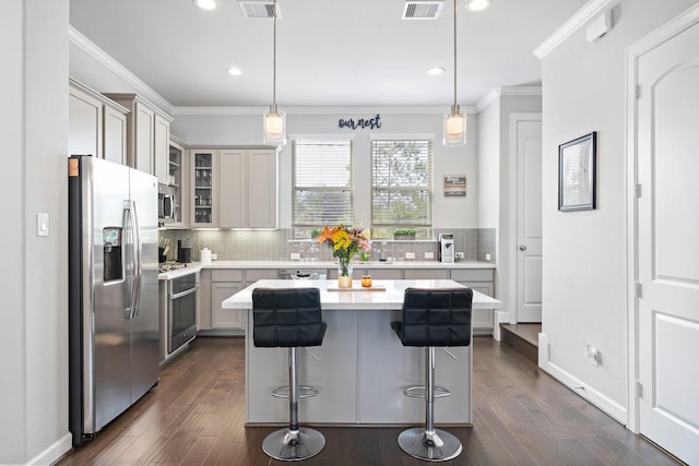 1509 Grayson Oaks Pl, Houston, TX 77043 - kitchen featuring stainless steel appliances, ornamental molding, backsplash, light countertops, and a kitchen bar