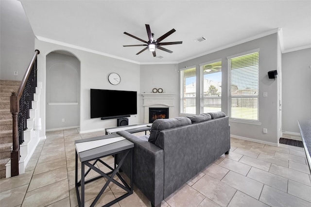 21283 Lily Springs Dr, Porter, TX 77365 - living room featuring ceiling fan, crown molding, a lit fireplace, stairway, and light tile patterned flooring