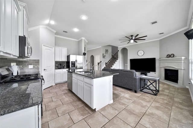 21283 Lily Springs Dr, Porter, TX 77365 - kitchen featuring appliances with stainless steel finishes, backsplash, white cabinets, a ceiling fan, and ornamental molding