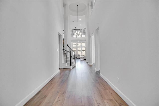 18702 Denio Site Dr, Cypress, TX 77433 - corridor featuring stairway, a towering ceiling, light wood finished floors, and a chandelier
