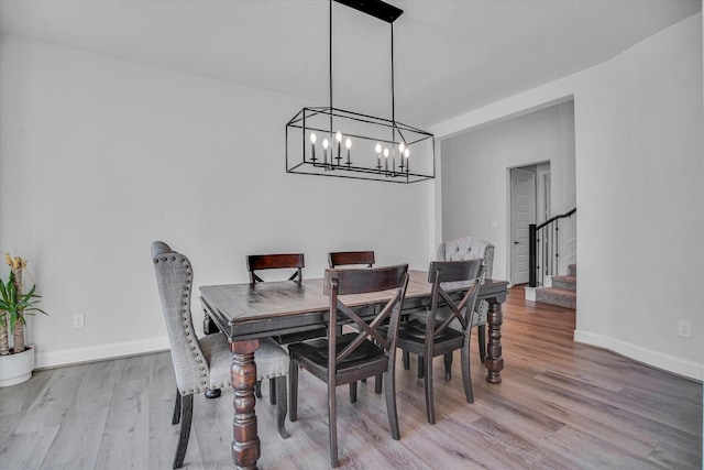 18702 Denio Site Dr, Cypress, TX 77433 - dining room featuring light wood-style flooring, a chandelier, and stairway