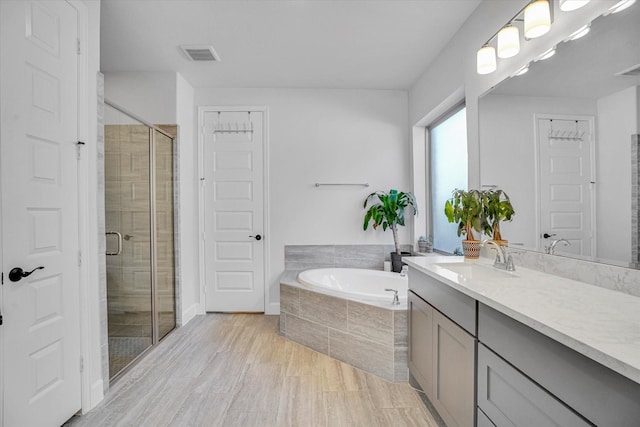 18702 Denio Site Dr, Cypress, TX 77433 - bathroom with vanity, a bath, a shower stall, and wood finished floors