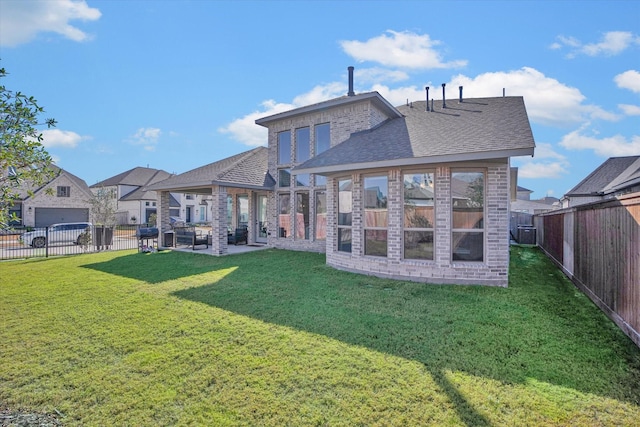 18702 Denio Site Dr, Cypress, TX 77433 - rear view of house with a fenced backyard, a patio area, a shingled roof, and brick siding