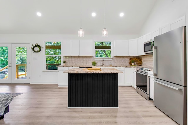 220 Tortuga Way, Point Blank, TX 77364 - kitchen with stainless steel appliances, a kitchen island, decorative backsplash, light stone counters, and white cabinets