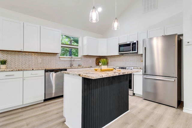 220 Tortuga Way, Point Blank, TX 77364 - kitchen featuring appliances with stainless steel finishes, light wood-style floors, light stone counters, tasteful backsplash, and white cabinetry