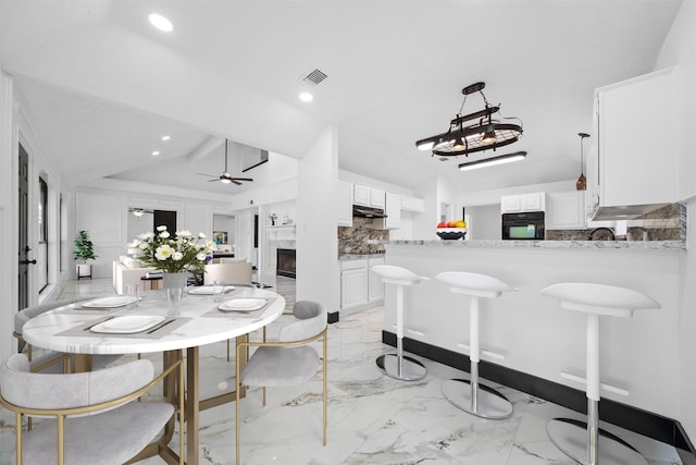 20923 Marcin Dr, Spring, TX 77388 - dining area featuring ceiling fan, a fireplace, lofted ceiling, recessed lighting, and light marble finish floors