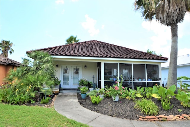 278 Debbie Ln, San Leon, TX 77539 - view of front of house with french doors, a tiled roof, stucco siding, and a sunroom