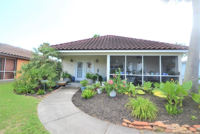 278 Debbie Ln, San Leon, TX 77539 - view of front of property featuring a tile roof, stucco siding, a sunroom, and a front yard