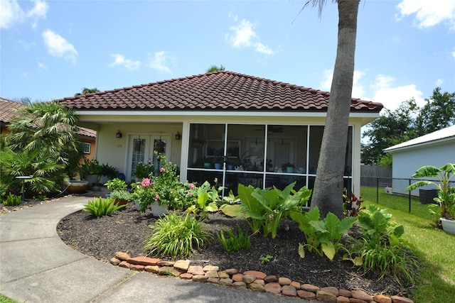 278 Debbie Ln, San Leon, TX 77539 - rear view of property featuring a tiled roof, stucco siding, and a sunroom