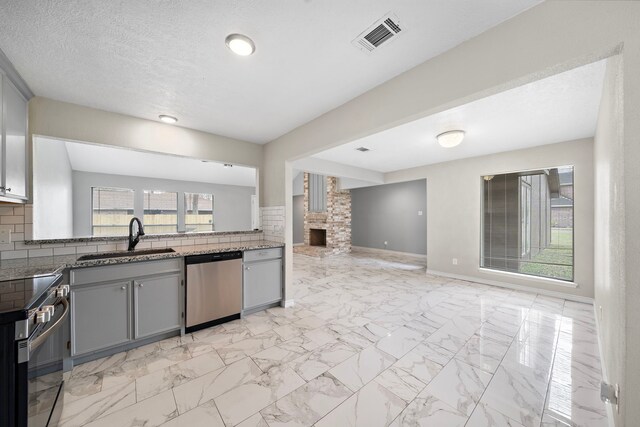 16111 Fan Tail Dr, Crosby, TX 77532 - kitchen with stainless steel appliances, gray cabinetry, open floor plan, and plenty of natural light