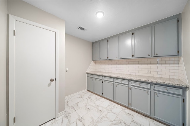 16111 Fan Tail Dr, Crosby, TX 77532 - kitchen with gray cabinets, light marble finish flooring, and tasteful backsplash