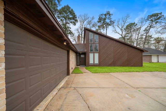 16111 Fan Tail Dr, Crosby, TX 77532 - view of home's exterior with driveway, a chimney, a lawn, and an attached garage