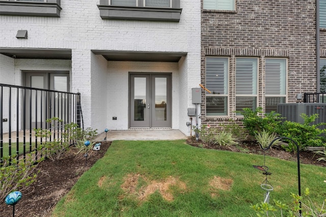 19911 Curved Steel Dr, Cypress, TX 77433 - property entrance with french doors, brick siding, and a lawn