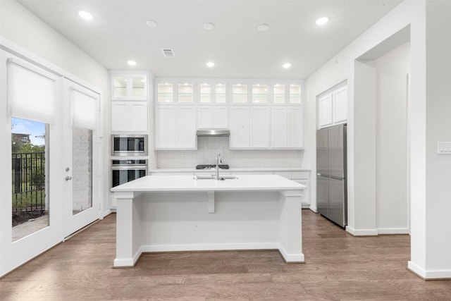 19911 Curved Steel Dr, Cypress, TX 77433 - kitchen with stainless steel appliances, an island with sink, under cabinet range hood, light countertops, and recessed lighting