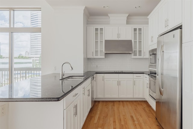 2211 Briarglen Dr Unit 502, Houston, TX 77027 - kitchen with stainless steel appliances, under cabinet range hood, plenty of natural light, a peninsula, and crown molding