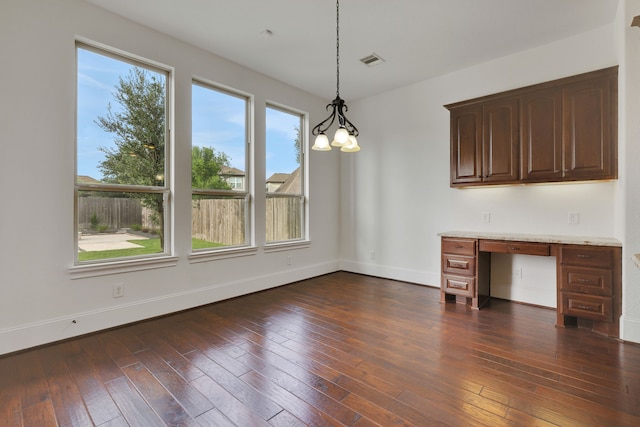 24918 Granite Bluff Ln, Katy, TX 77494 - unfurnished dining area with built in desk, healthy amount of natural light, dark wood-style floors, and a chandelier