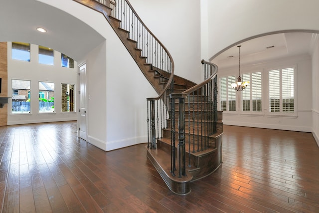 24918 Granite Bluff Ln, Katy, TX 77494 - stairway featuring arched walkways, healthy amount of natural light, a chandelier, hardwood / wood-style floors, and a towering ceiling