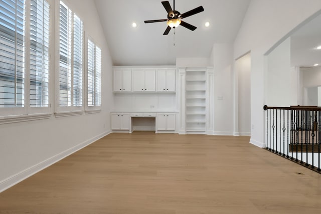 24918 Granite Bluff Ln, Katy, TX 77494 - unfurnished living room featuring built in study area, ceiling fan, light wood-style flooring, recessed lighting, and high vaulted ceiling
