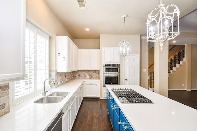 22602 Water Edge Ln, Katy, TX 77494 - kitchen featuring blue cabinetry, stainless steel appliances, a chandelier, white cabinets, and healthy amount of natural light