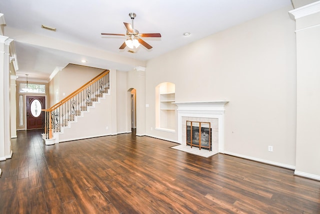 22602 Water Edge Ln, Katy, TX 77494 - unfurnished living room with a ceiling fan, wood finished floors, a tiled fireplace, built in shelves, and stairway
