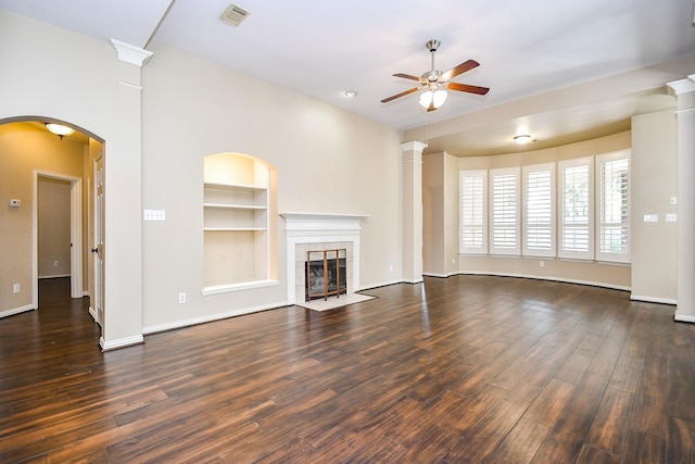 22602 Water Edge Ln, Katy, TX 77494 - unfurnished living room featuring ceiling fan, built in shelves, dark wood finished floors, and a tile fireplace