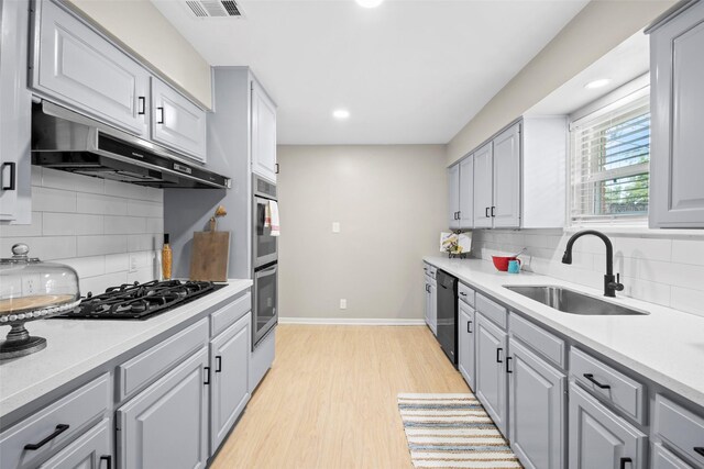 9614 Hammerly Blvd, Houston, TX 77080 - kitchen featuring under cabinet range hood, black appliances, decorative backsplash, gray cabinets, and recessed lighting