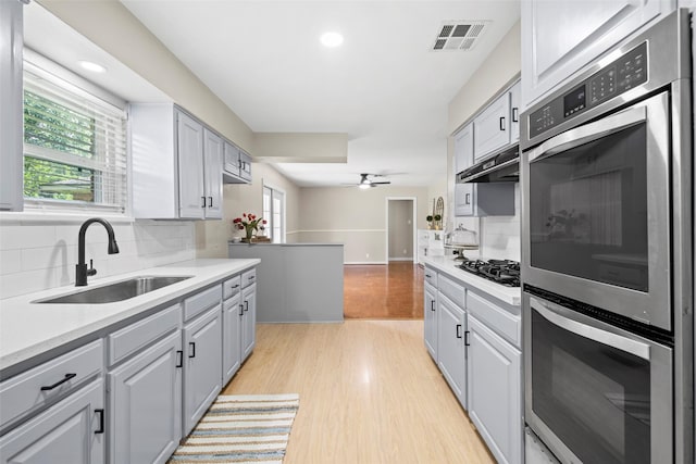 9614 Hammerly Blvd, Houston, TX 77080 - kitchen featuring decorative backsplash, light wood finished floors, light countertops, and recessed lighting