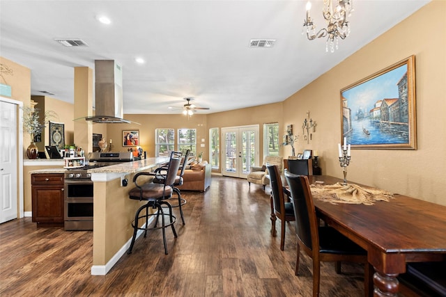 847 Cottletown Rd, Smithville, TX 78957 - kitchen featuring double oven range, ventilation hood, open floor plan, dark wood finished floors, and a breakfast bar area