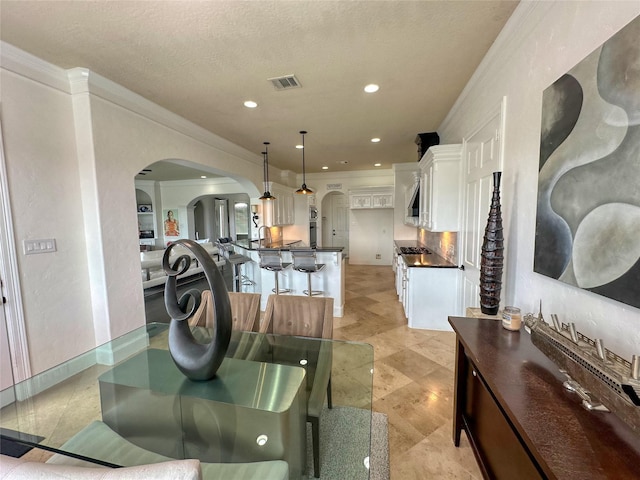 12571 St Ann Ct, Willis, TX 77318 - dining area featuring arched walkways, ornamental molding, and recessed lighting