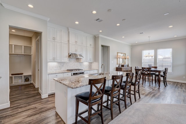 3207 Coach Horse Ln, Houston, TX 77080 - kitchen featuring wood finished floors, ornamental molding, light stone countertops, white cabinetry, and tasteful backsplash