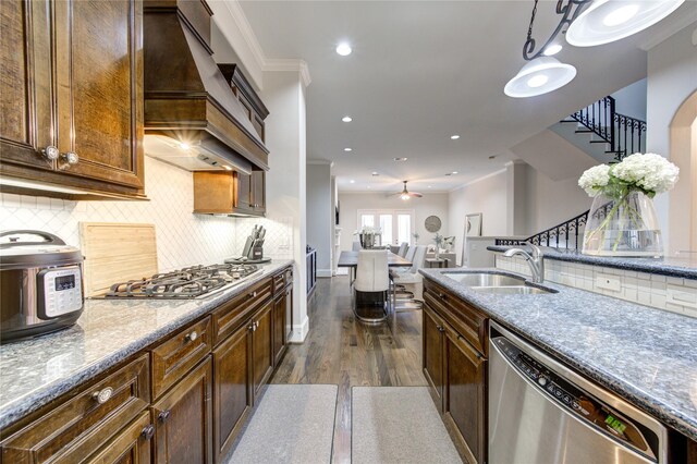 5531 Pine St Unit H, Houston, TX 77081 - kitchen with stainless steel appliances, custom exhaust hood, dark wood-style floors, a ceiling fan, and backsplash