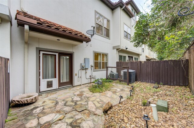 5531 Pine St Unit H, Houston, TX 77081 - back of house featuring a fenced backyard, stucco siding, a tiled roof, and a patio area