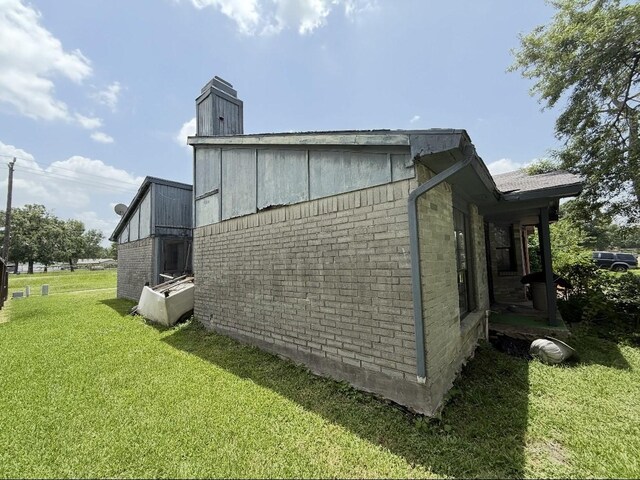 14138 Dartwood Dr, Houston, TX 77049 - view of side of property with brick siding, a lawn, and a chimney